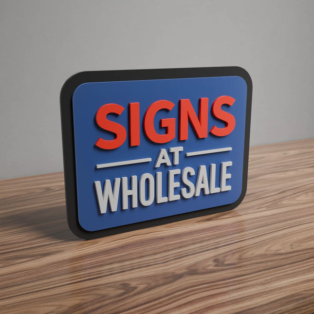Multi-layered 3D sign with bold red and white letters reading 'Signs at Wholesale' on a blue background, placed on a wooden surface